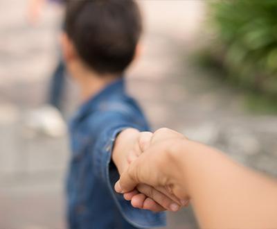  Boy looking back and pulling away from parent